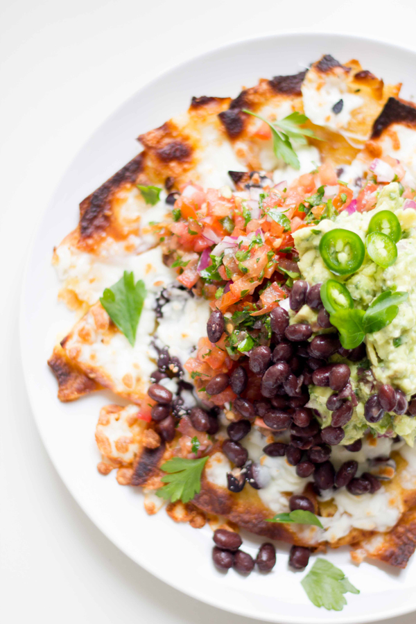 This vegetarian homemade nachos recipe is made with melted mozzarella cheese, black beans, pico de gallo, and homemade guacamole. It's definitely a meal your whole family will enjoy! | www.seriousspice.com
