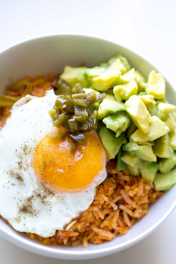 This yummy rice bowl recipe is made with spicy tomato cabbage rice topped with diced avocado, pickled jalapeños and a fried egg! | www.seriousspice.com