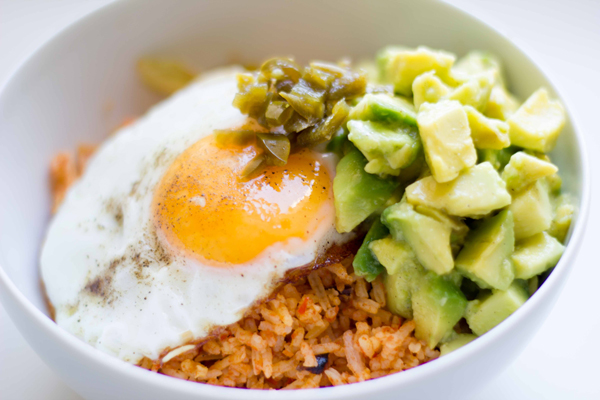 This yummy rice bowl recipe is made with spicy tomato cabbage rice topped with diced avocado, pickled jalapeños and a fried egg! | www.seriousspice.com